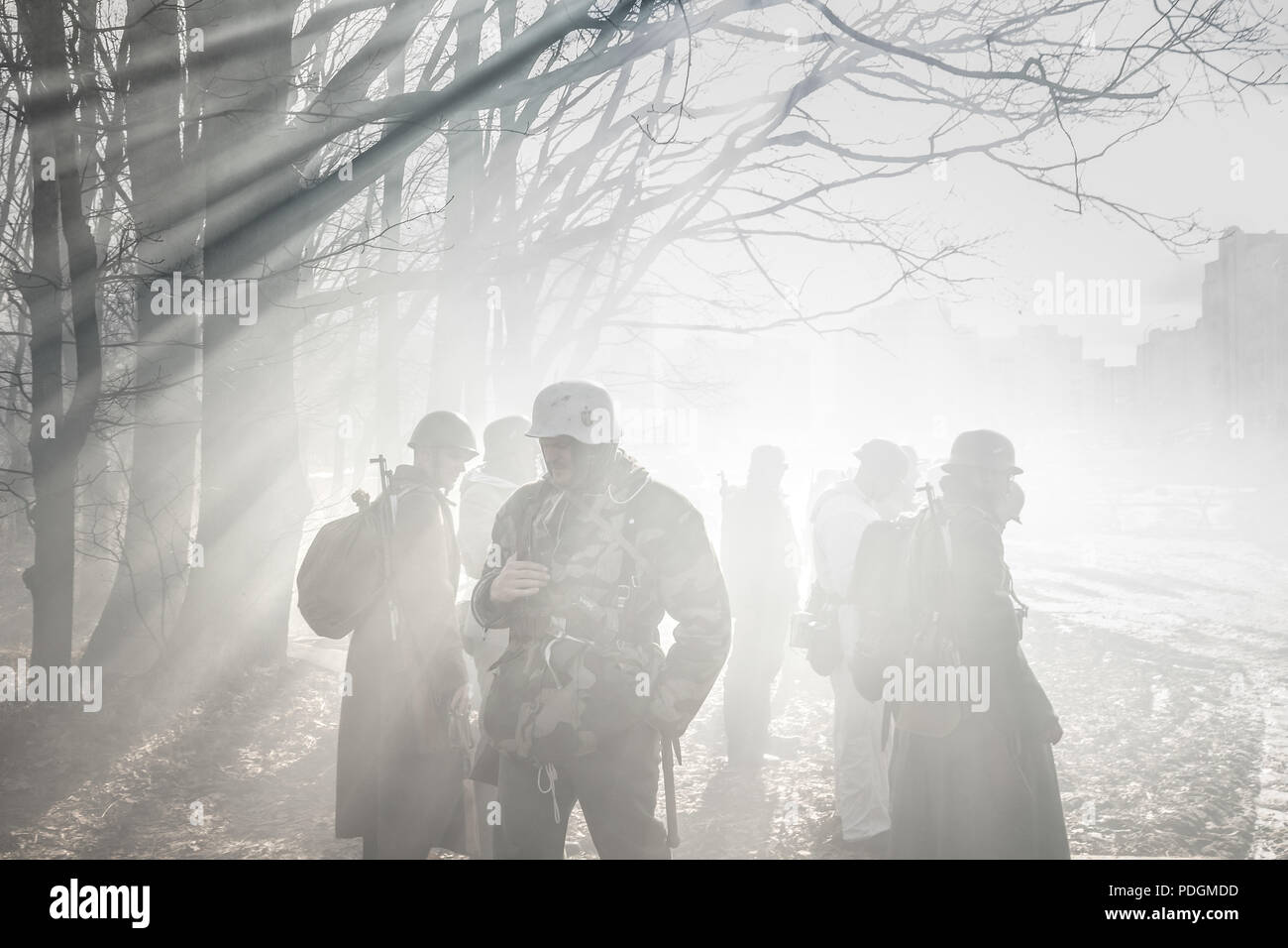 Rogachev, Bielorussia - Febbraio 25, 2017: Re-enactors vestito come il tedesco della Wehrmacht Soldato di fanteria nella guerra mondiale II In piedi In drammatico attraverso la retroilluminazione Foto Stock