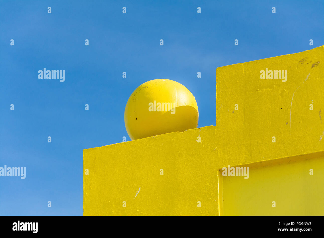 Dettagli architettonici gialli luminosi accostati al cielo blu pallido. La combinazione di geometria e colore evoca sensazioni positive. Foto Stock