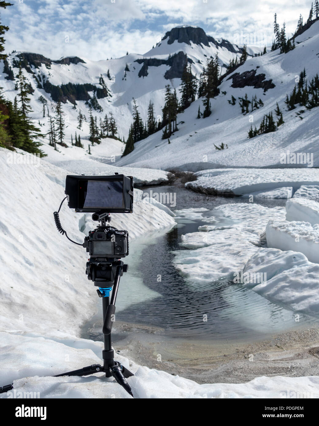 Professional setup video cattura di sorprendente fusione di neve natura riprese con alto picco di montagna in backround Foto Stock