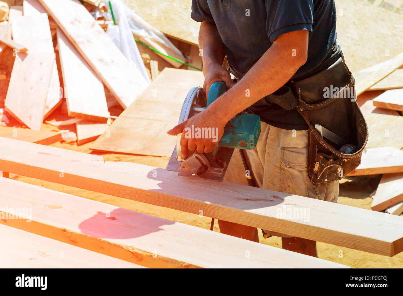 Nuovo home progetto constructiion imprenditore edile lavoratore utilizzando tenuto in mano unità worm sega circolare per il taglio di pannelli Foto Stock