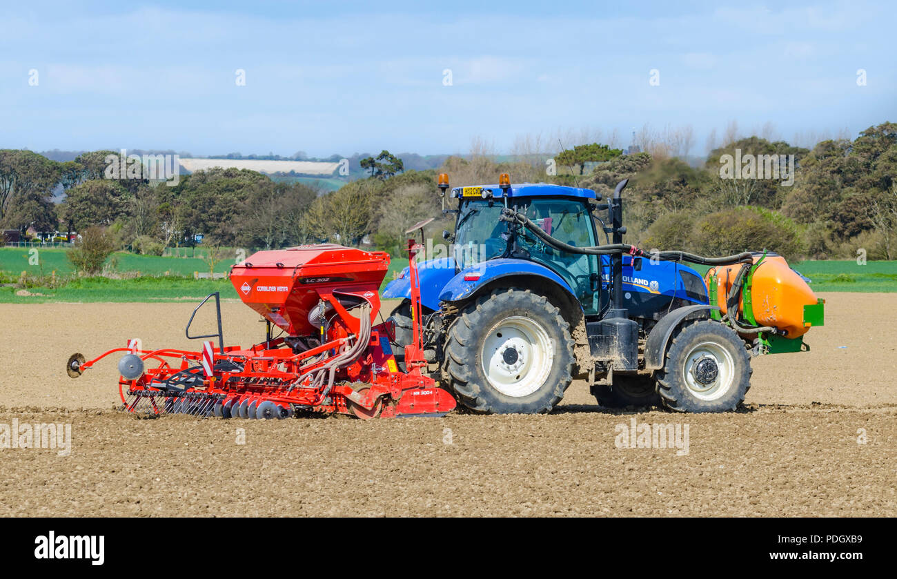 Piantare i semi in un campo con un trattore New Holland tirando un Kahn HR 3004 trogolo e LC 302 Combiliner Venta seminatrice nel West Sussex, Regno Unito. Foto Stock