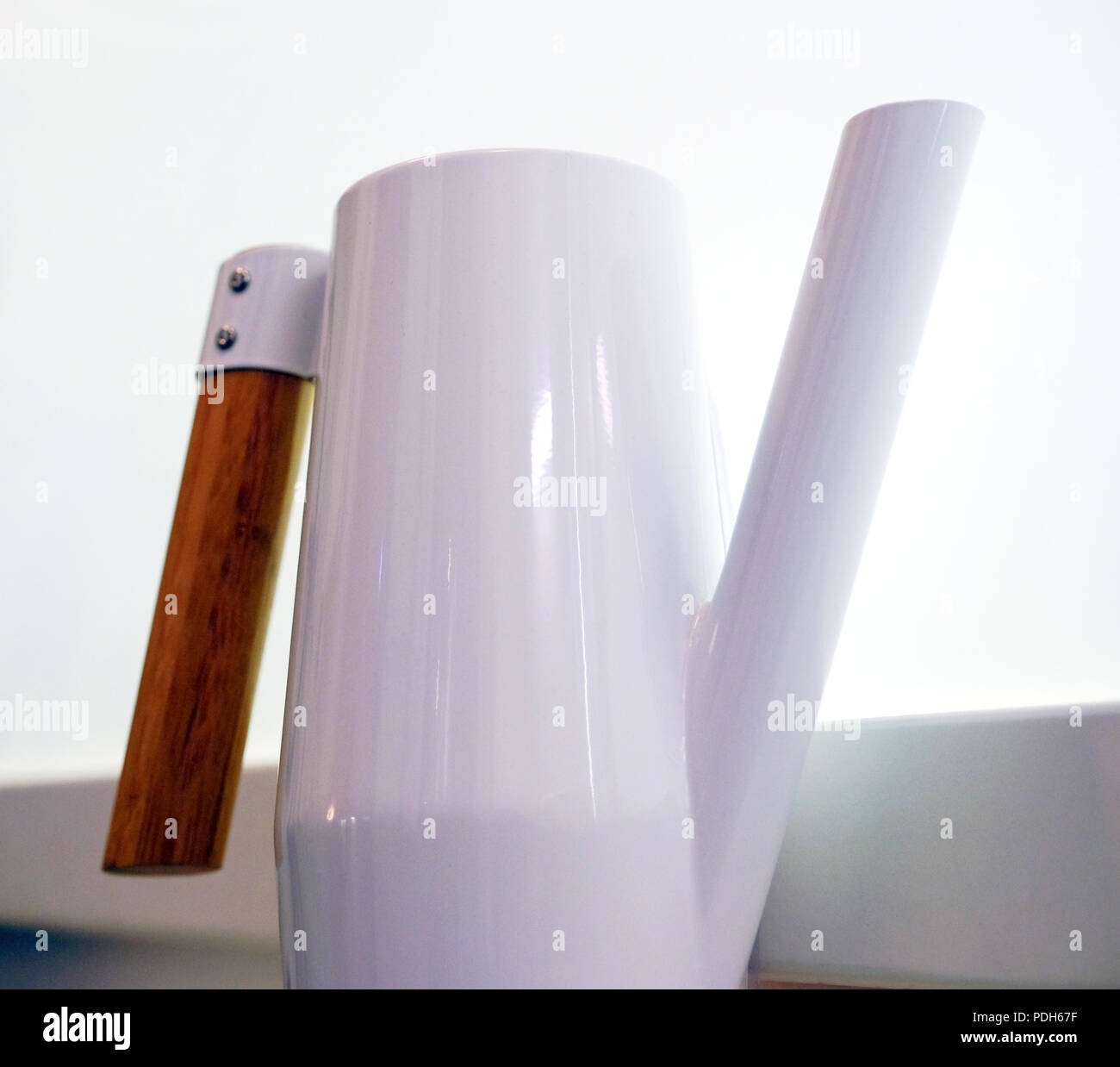 Bianco acciaio inossidabile brocca con manico in legno. Sullo sfondo della finestra. Foto Stock