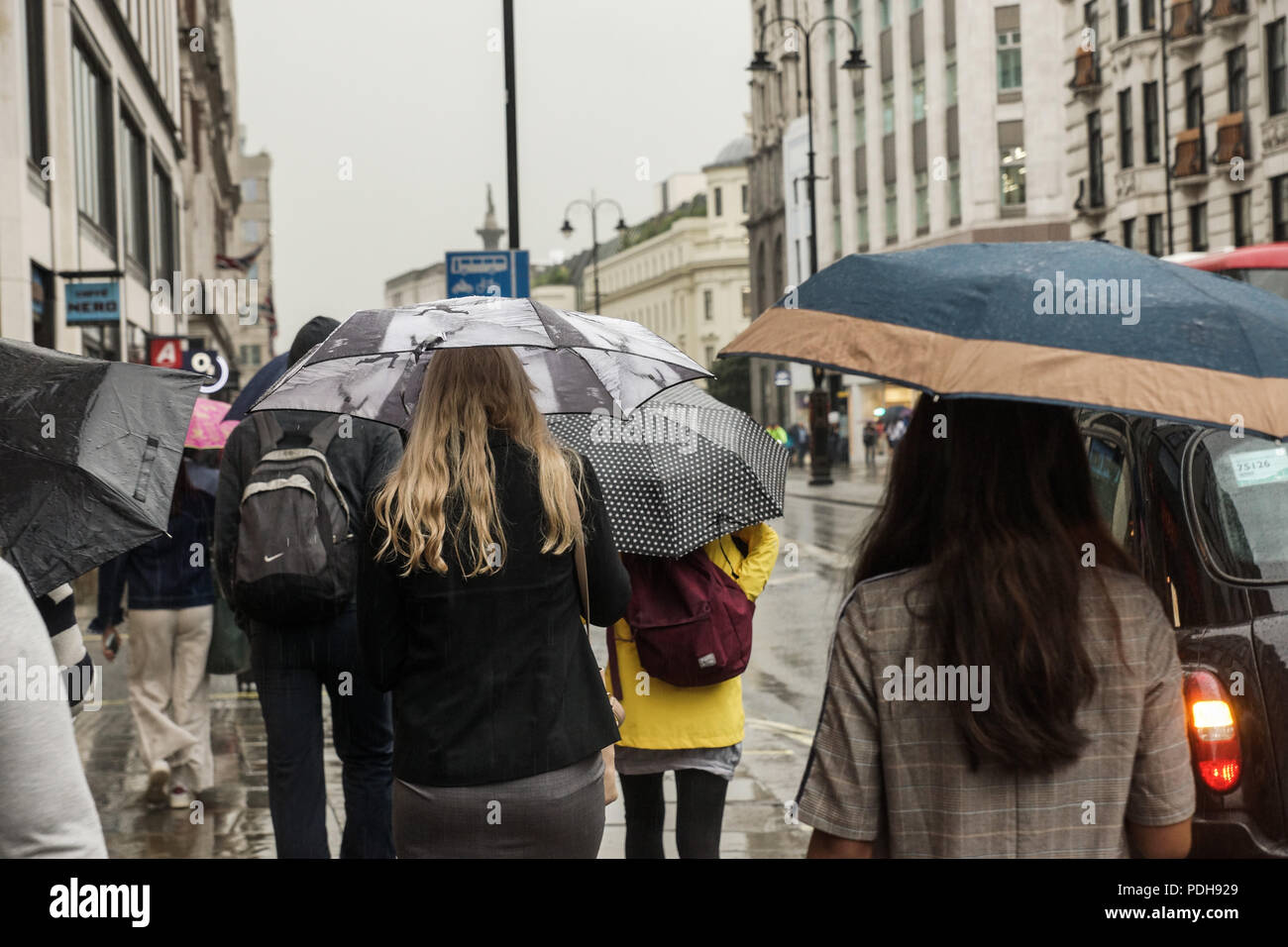 Londra, Regno Unito. Il 9 agosto, 2018. Tipico inglese estate ritorna al filamento nel centro di Londra. Il record caldo ha dato modo a più tipicamente meteo inglese come heavy rain versata su The Strand in centro a Londra. Ombrelloni e luce calzature estive fatte incongruo partnership come autobus, automobili, taxi, ciclisti e pedoni tutti braved il diluvio come sono andati i loro affari. © Peter Hogan/Alamy Live News Foto Stock