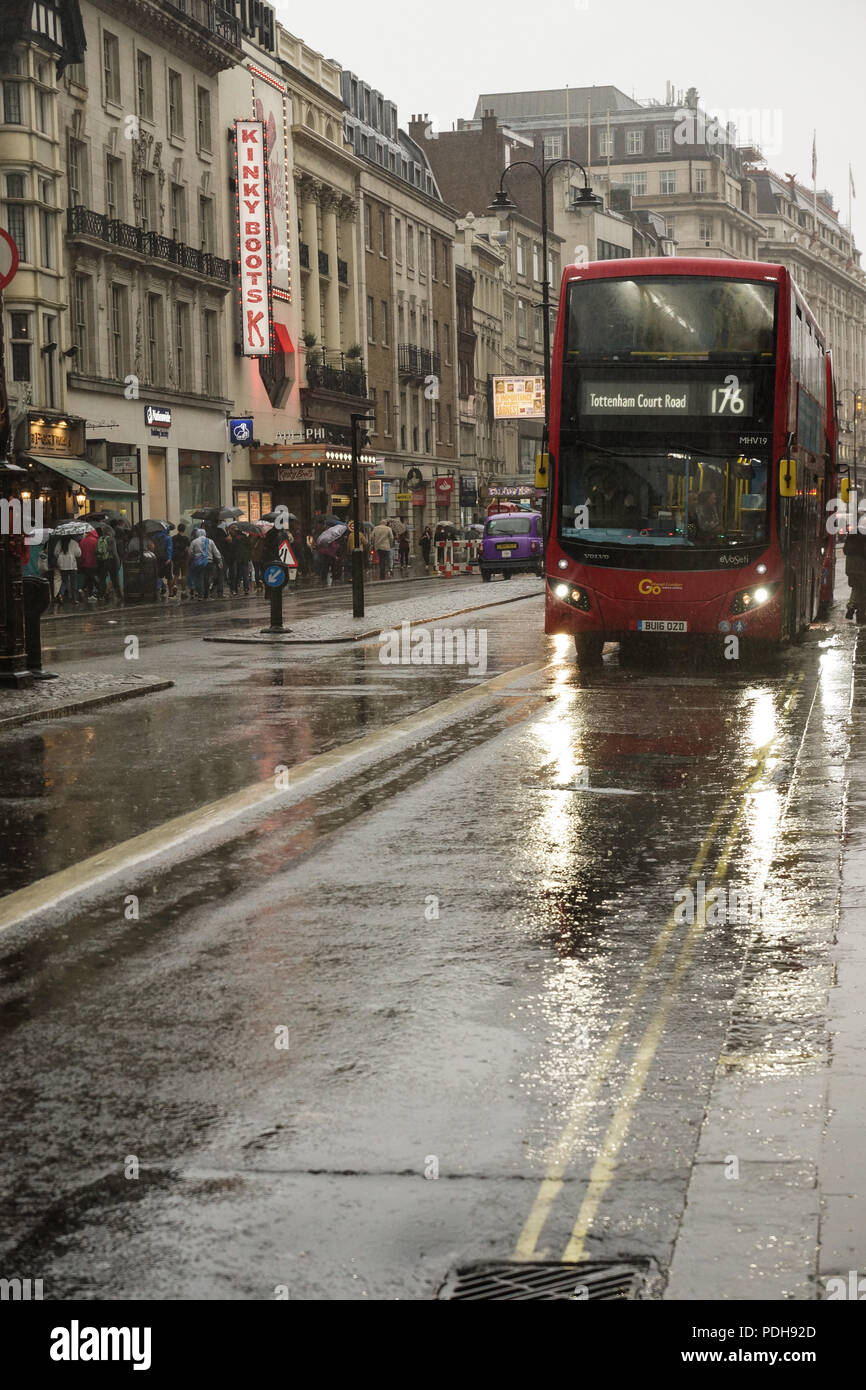 Londra, Regno Unito. Il 9 agosto, 2018. Tipico inglese estate ritorna al filamento nel centro di Londra. Il record caldo ha dato modo a più tipicamente meteo inglese come heavy rain versata su The Strand in centro a Londra. Ombrelloni e luce calzature estive fatte incongruo partnership come autobus, automobili, taxi, ciclisti e pedoni tutti braved il diluvio come sono andati i loro affari. © Peter Hogan/Alamy Live News Foto Stock