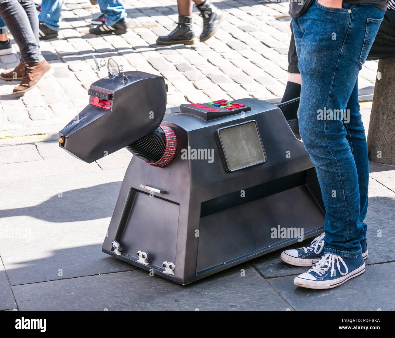 Edimburgo, Scozia, Regno Unito. Il 9 agosto 2018. Edinburgh Fringe Festival Royal Mile di Edimburgo, Scozia, Regno Unito. Su un soleggiato giorno del festival la Vergine denaro sponsorizzato street festival è gremita di gente ed esecutori della frangia. Un uomo il controllo di un manipolatore robotico di un K9 cane Foto Stock