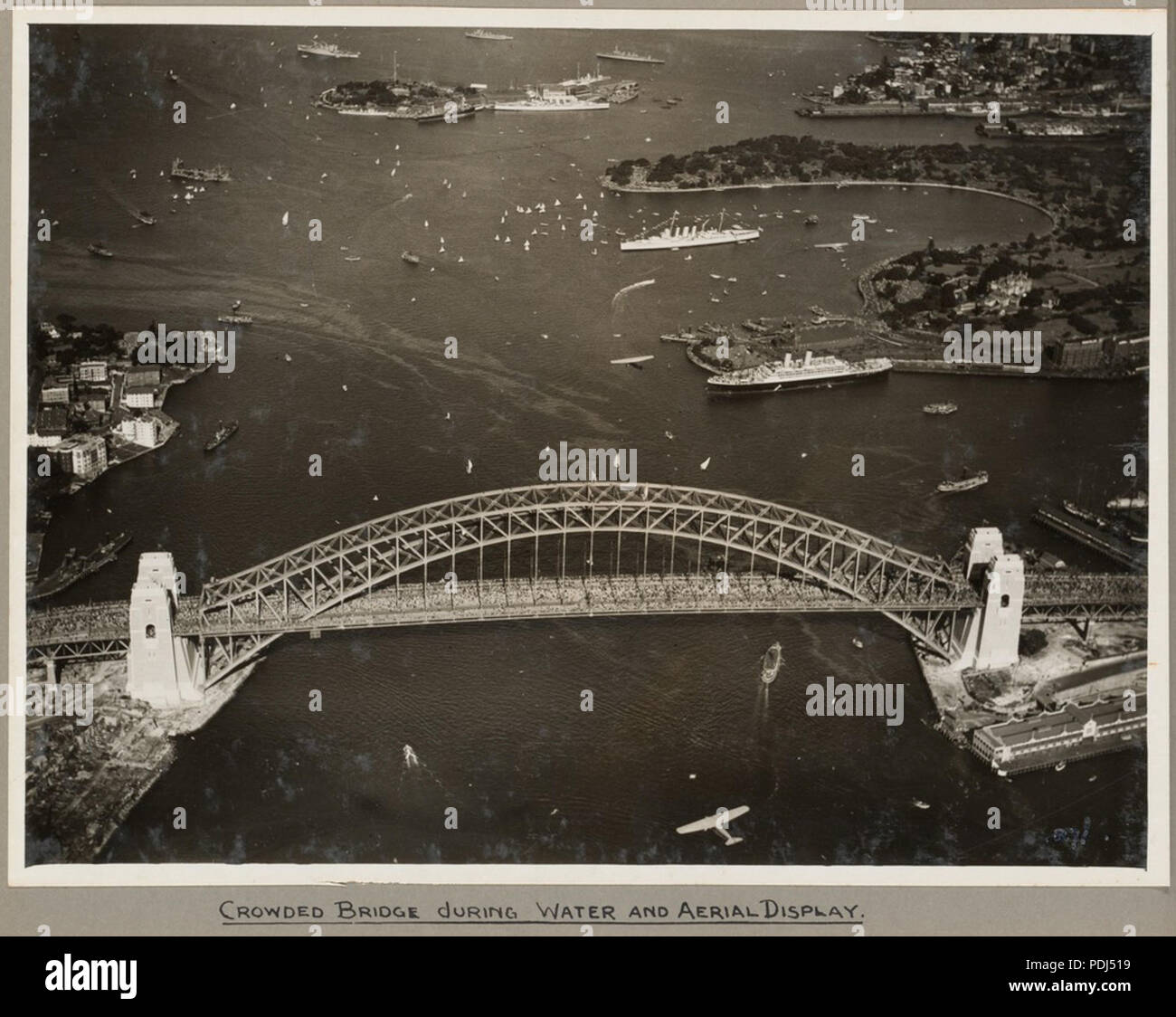 310 Sydney Harbour Bridge affollato di spettatori durante l'acqua e display antenna, 19 marzo 1932 (6173531979) Foto Stock