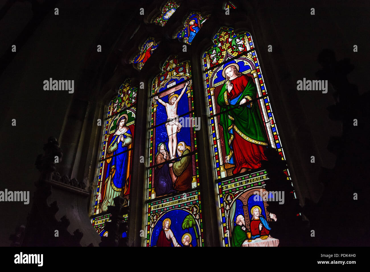 Una macchia di finestra vetrata raffigurante la crocifissione di Gesù Cristo (progettato da Giuseppe Campana, 1858), presso la chiesa di Saint Mary, Hopesay, Shropshire, Regno Unito. Foto Stock
