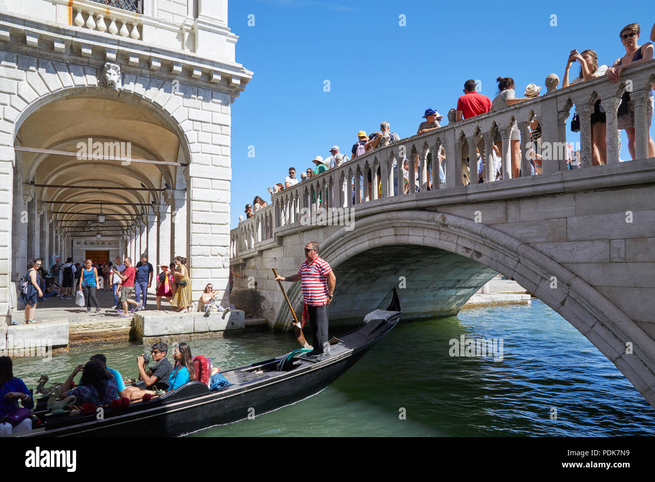 Cittadini e turisti sul ponte e gondola a Venezia in una soleggiata giornata estiva in Italia Foto Stock