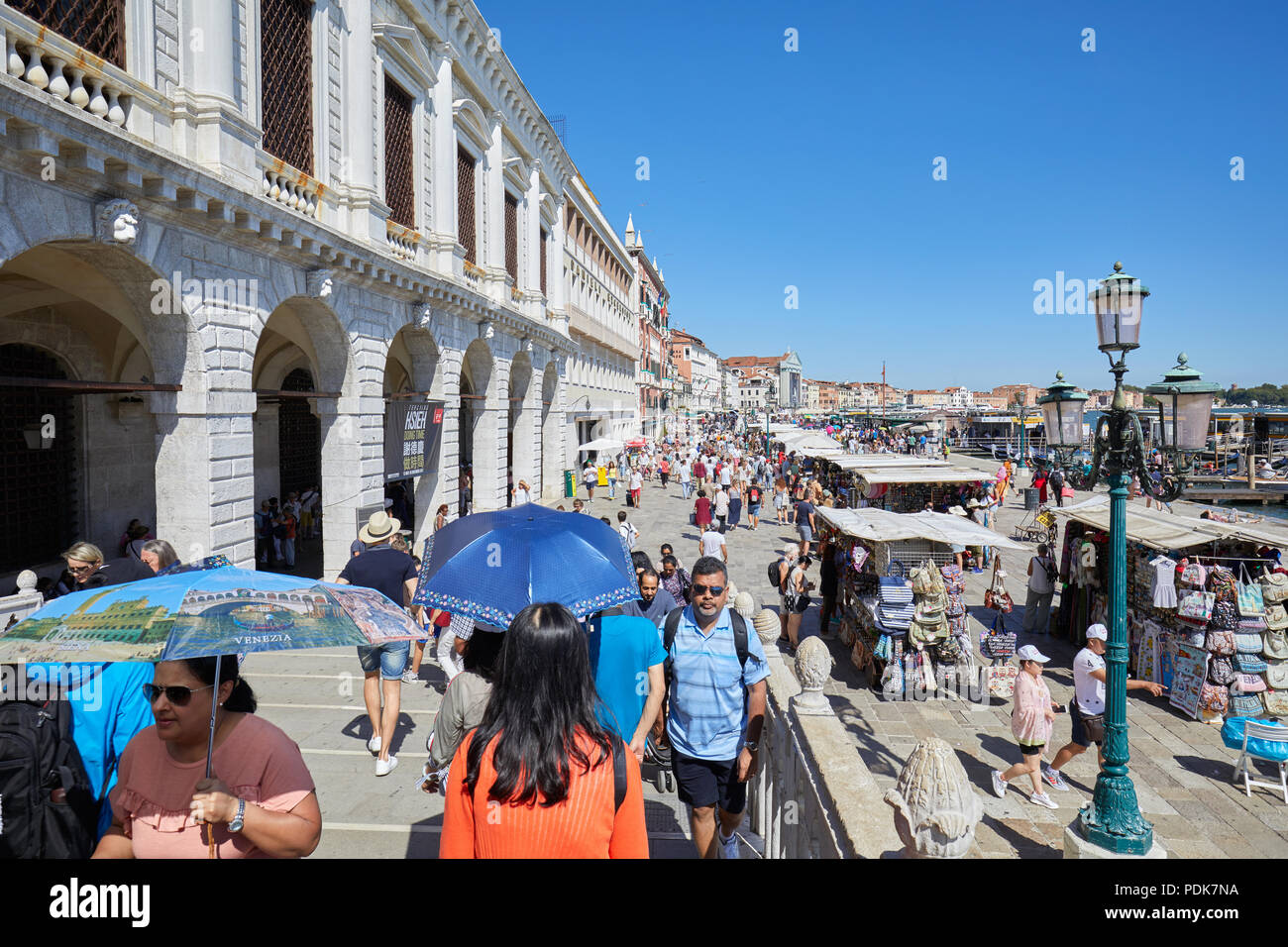 Cittadini e turisti a Venezia con ombrelloni a mezzogiorno nei pressi di Piazza San Marco in una soleggiata giornata estiva in Italia Foto Stock