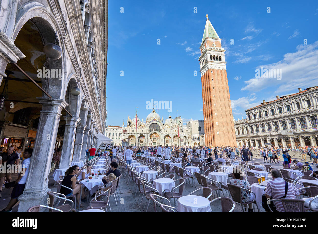 Piazza San Marco con il marciapiede tabella con cittadini e turisti, cielo blu in una soleggiata giornata estiva in Italia Foto Stock