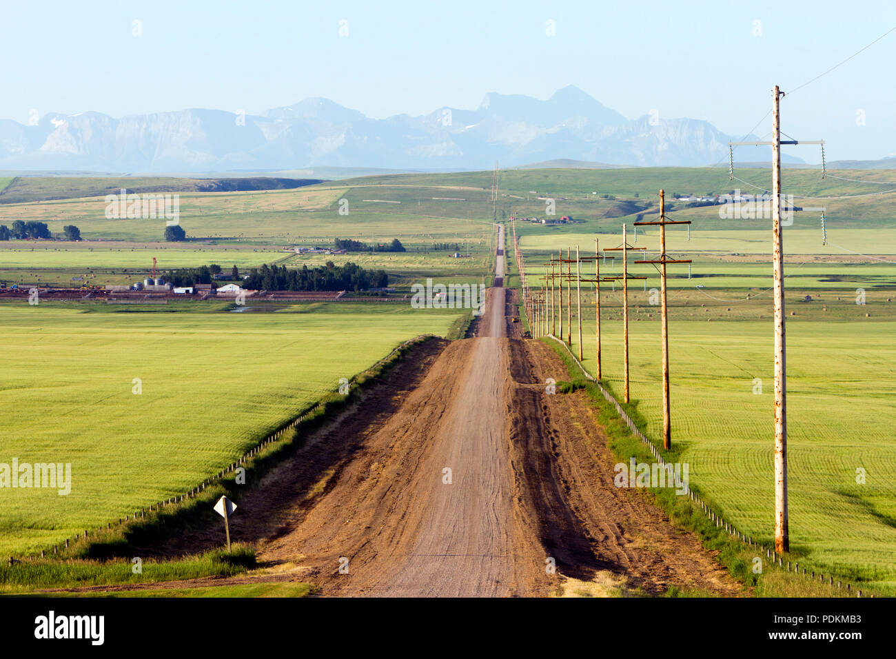 Una strada di campagna in un paesaggio rurale nella insenatura del rullo di estrazione, Alberta, Canada. Foto Stock