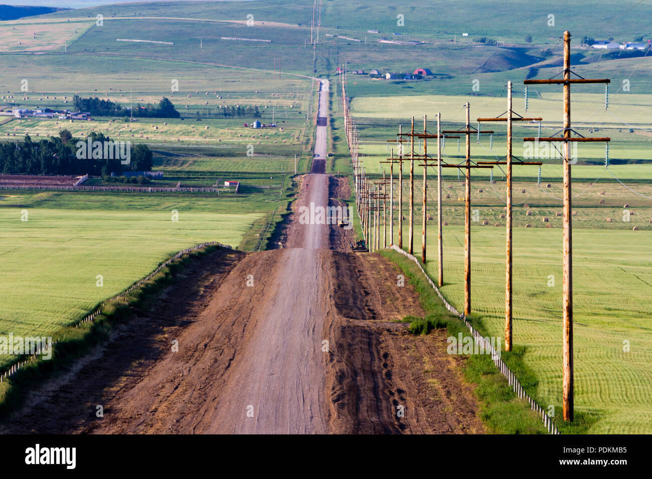 Una strada di campagna in un paesaggio rurale nella insenatura del rullo di estrazione, Alberta, Canada. Foto Stock