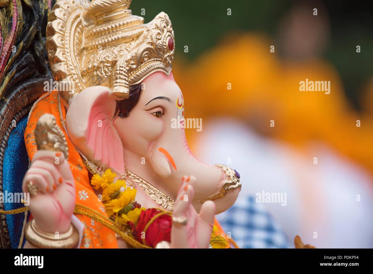 Un idolo con un profilo di divina del Signore Ganesha l'elefante-intitolata dio indù figlio del Signore Shiva e Parvati con un copricapo dorati e una ghirlanda di fiori Foto Stock