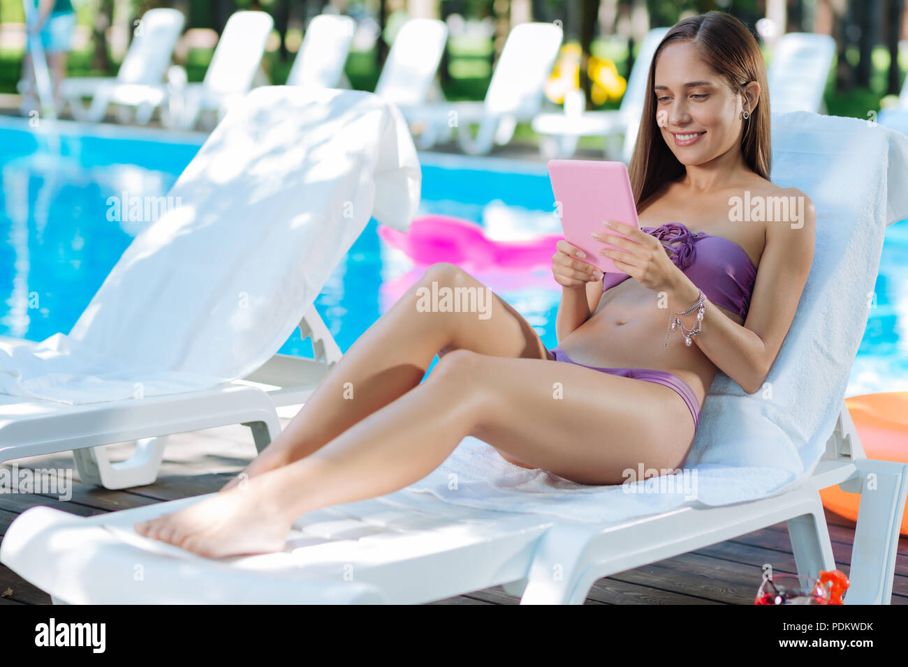 Donna Moderna la lettura di libri elettronici mentre si prende il sole Foto Stock