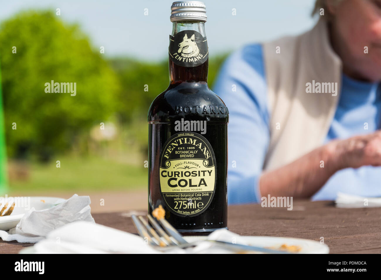 Una bottiglia di Fentimans curiosità Cola su un tavolo da picnic. Foto Stock