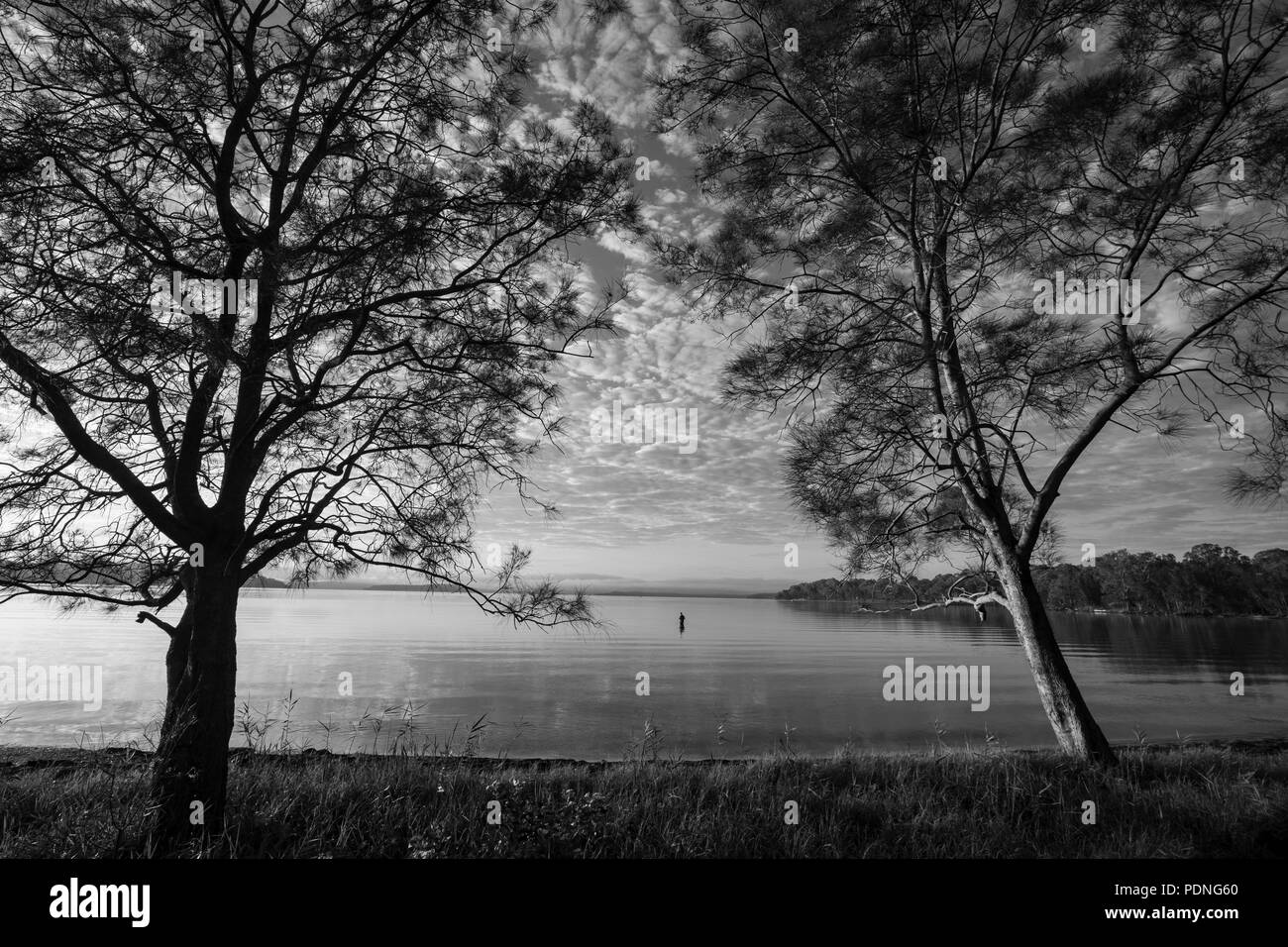Lago tranquillo scena con un pescatore Foto Stock