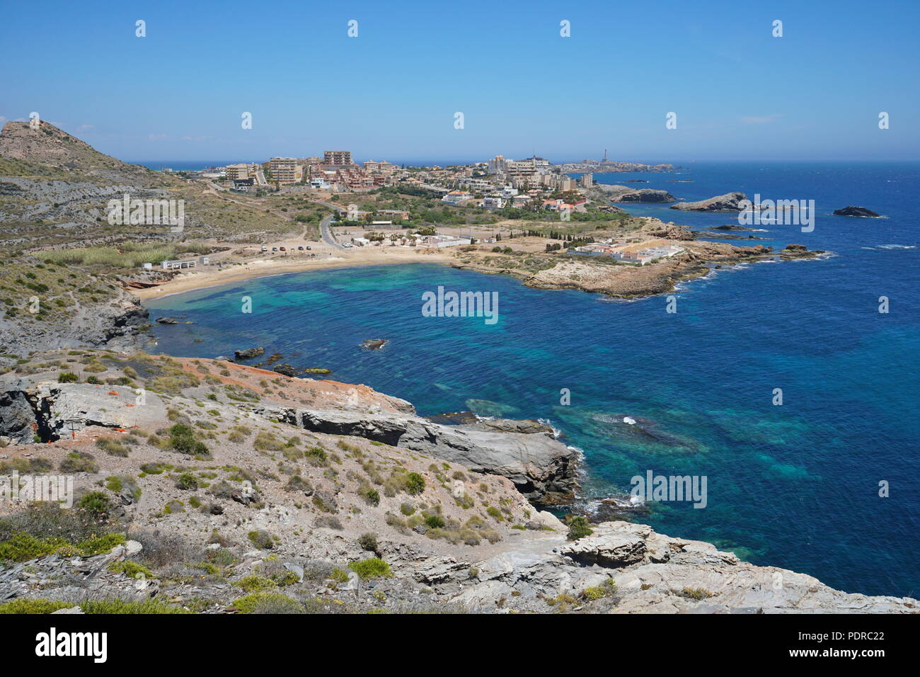 Spagna Il paesaggio costiero, costa rocciosa con spiaggia di sabbia nella cittadina balneare di Cabo de Palos, Cartagena, Murcia, mare Mediterraneo Foto Stock