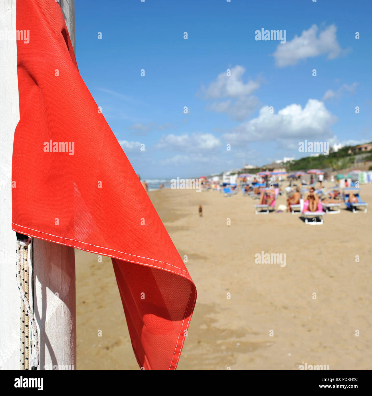 Una spia rossa bandiera sulle belle spiagge del Mar Tirreno. Sabaudia, Lazio, Italia Foto Stock