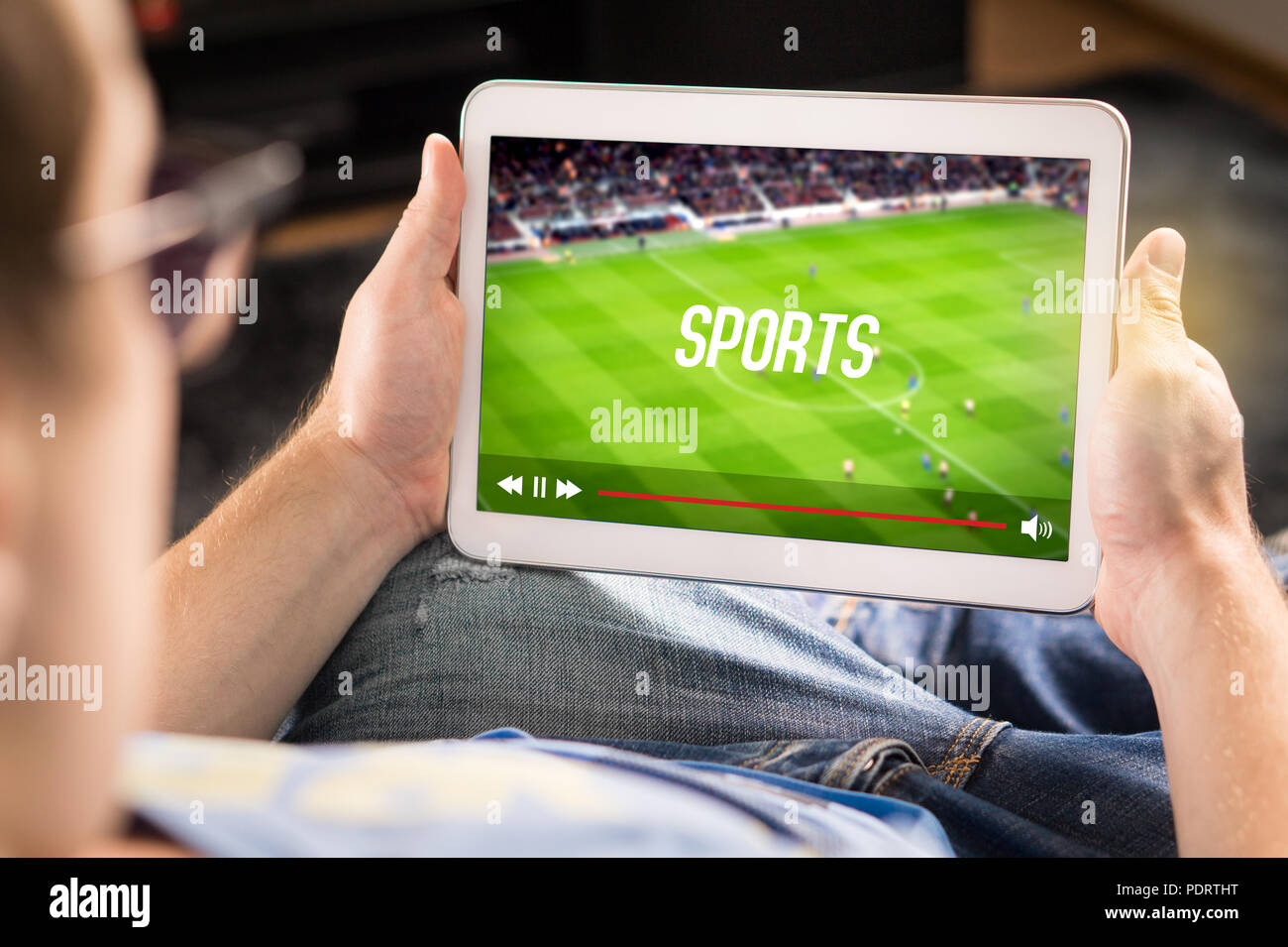 L'uomo guardare sport su tablet. Il calcio e la partita di calcio in diretta streaming e lettore video sullo schermo. Pay per view (PPV) servizio. Foto Stock