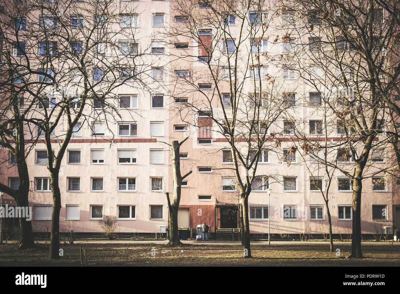 Vista frontale di un vecchio edificio di appartamenti con un uomo durante il periodo invernale Foto Stock