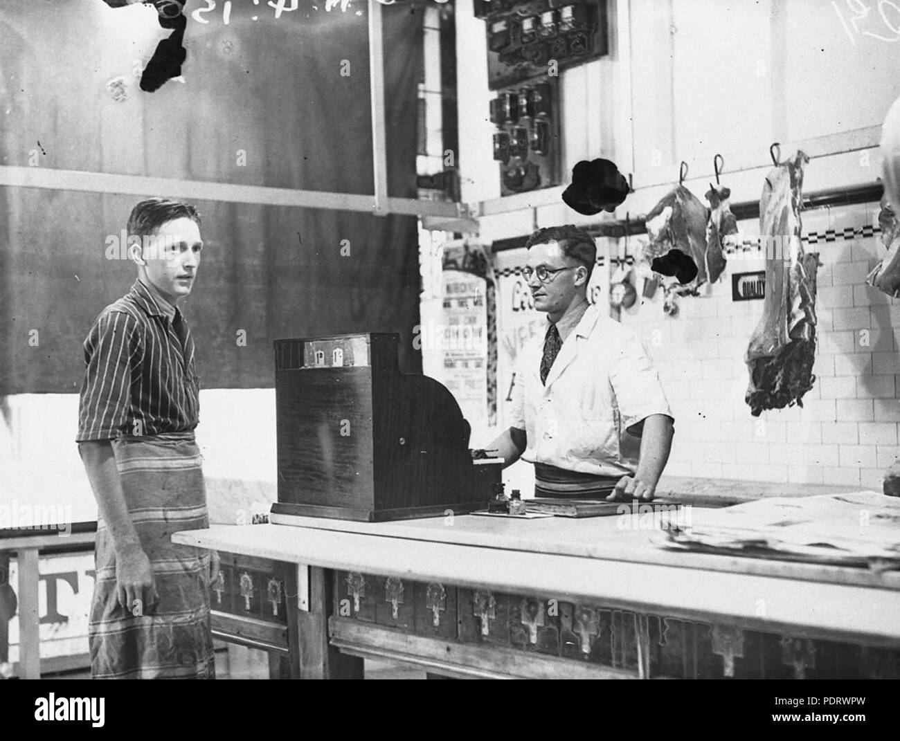 161 43504 SLNSW Fred Saville macellaio di Earlwood e il suo assistente dopo una rapina dove il ladro ha chiesto 2 libbre dalla cassa Foto Stock