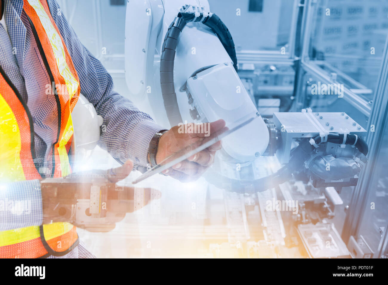 Lavoratore utilizzando il controllo tablet braccio di robot in linea di produzione per la robotica concetto di ingegneria Foto Stock