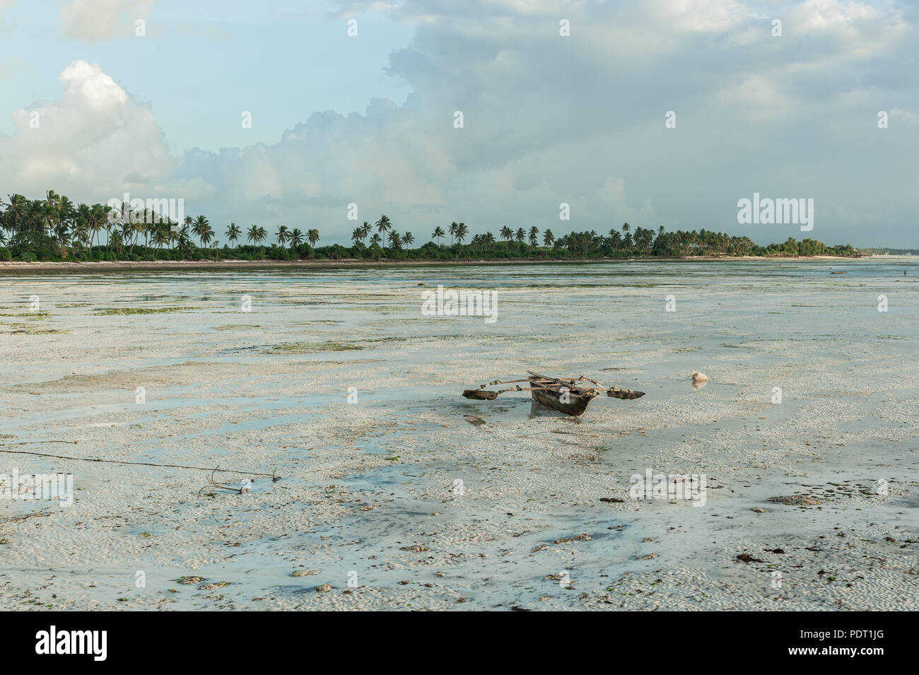 La pesca tradizionale barca sulla sabbia con la bassa marea. Panorama sull'isola di Zanzibar, Tanzania Foto Stock