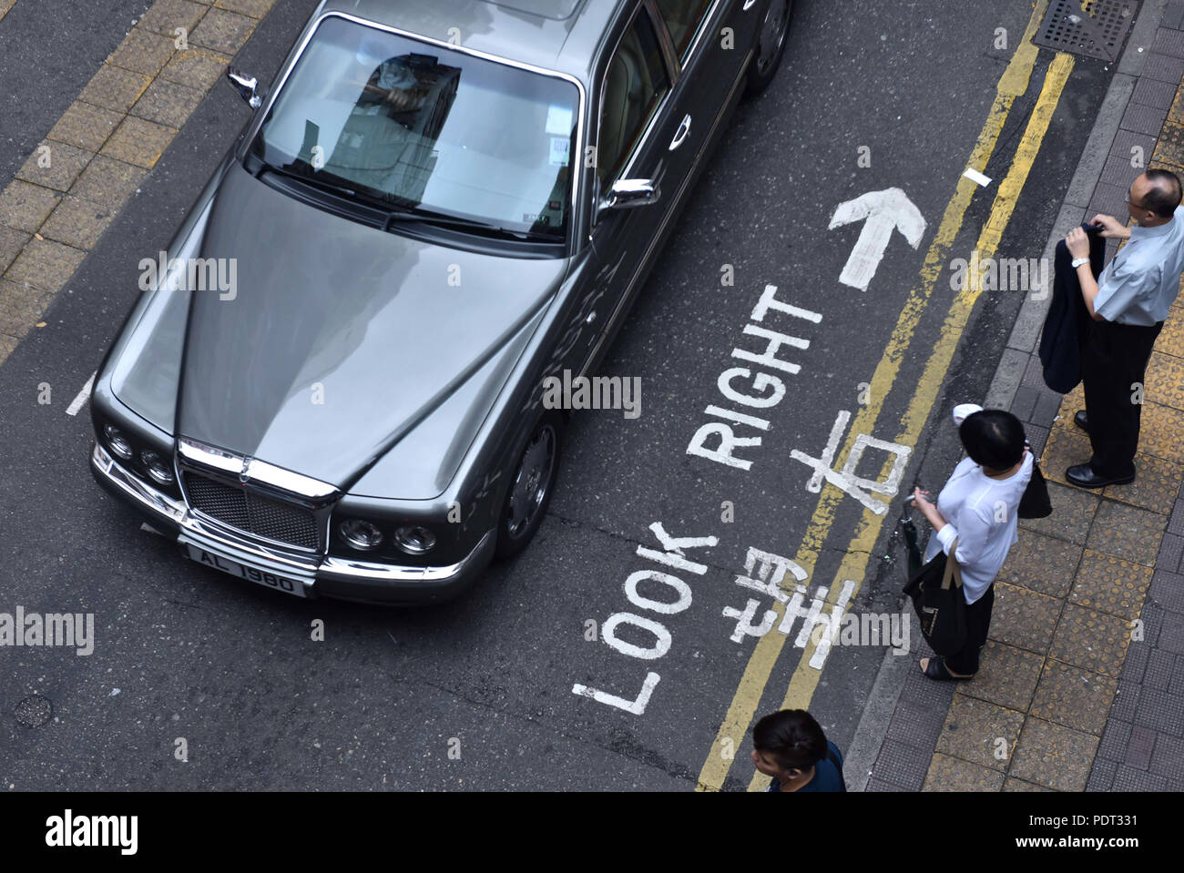 Cina Hong Kong Pedone In Attesa Su Un Marciapiede Con La Segnaletica Stradale In Inglese E
