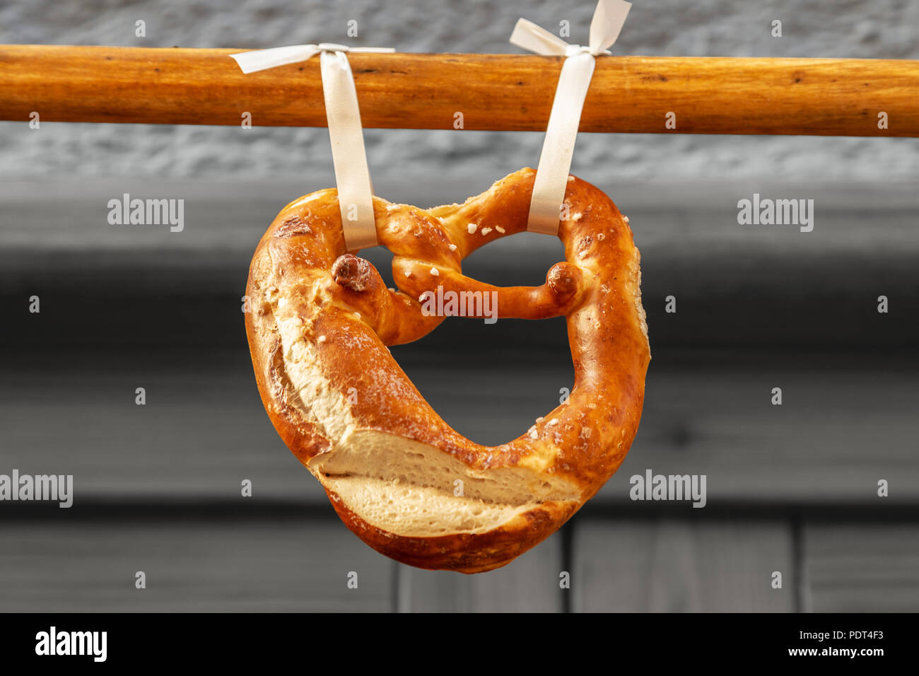 Un pretzel o brezel in tedesco appesi su una barra di legno, tipica cucina bavarese e birra snack Foto Stock