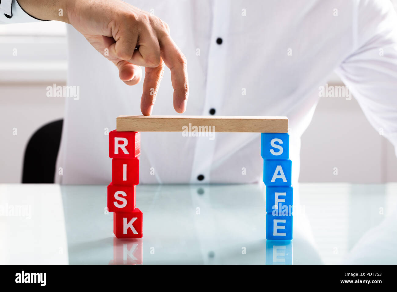 Close-up di una persona del dito attraversando ponte di legno di rischio e blocco di sicurezza Foto Stock