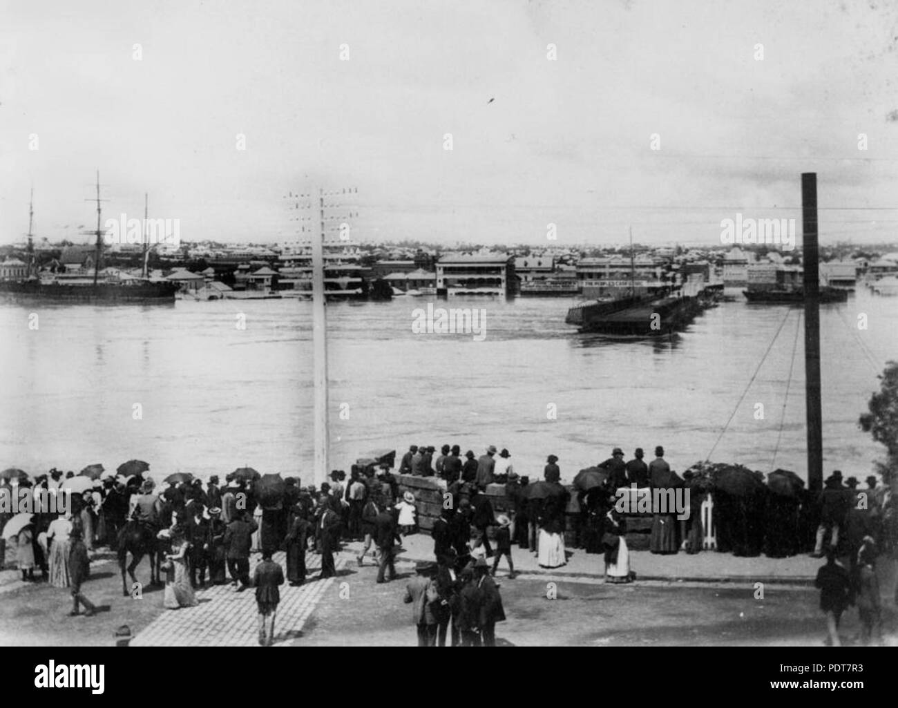 244 StateLibQld 1 179883 folla raccolta sulla sponda nord del Fiume Brisbane, osservando le acque alluvionali che lavato via Ponte Victoria, 1893 Foto Stock