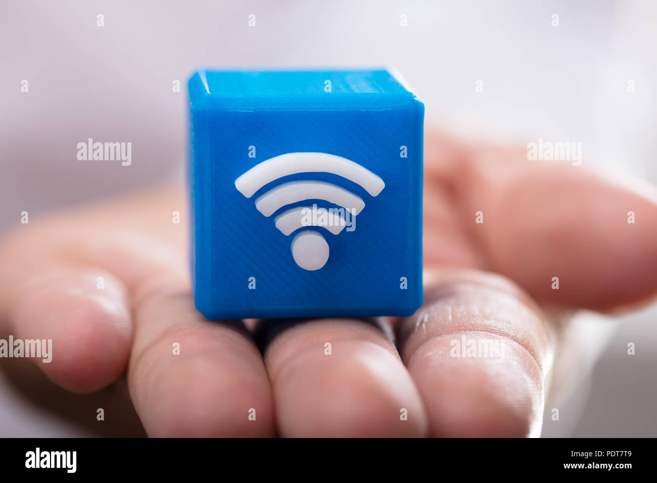 Close-up di mano di una persona azienda blu blocco cubico con icona wireless Foto Stock