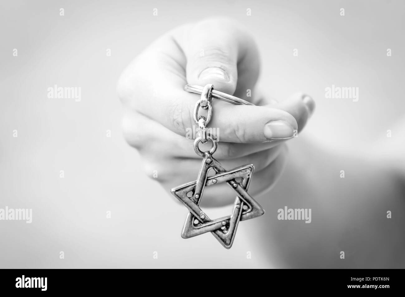 Giovane donna di mano che tiene una stella di Davide, Magen David chiave catena. Stato di Israele, l'ebraismo, il Sionismo o antisemitismo concetto. Ricordo dell'olocausto. Foto Stock