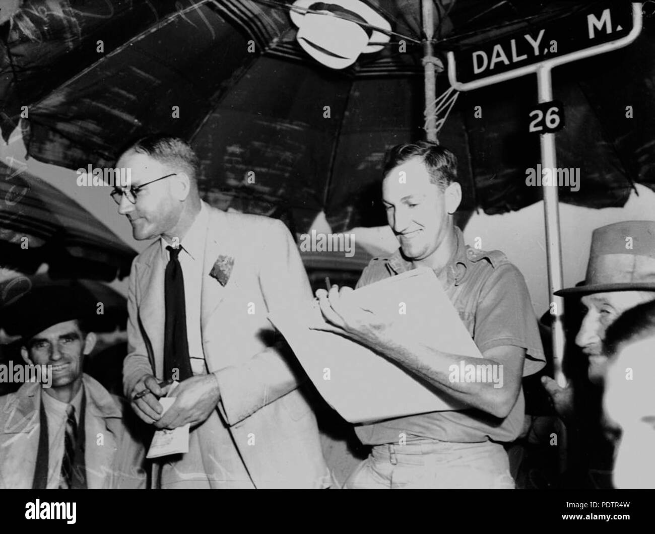 201 StateLibQld 1 103856 Bookmaker M. Daly e assistente Ray Duncan alle gare, Brisbane, 18 aprile 1942 Foto Stock