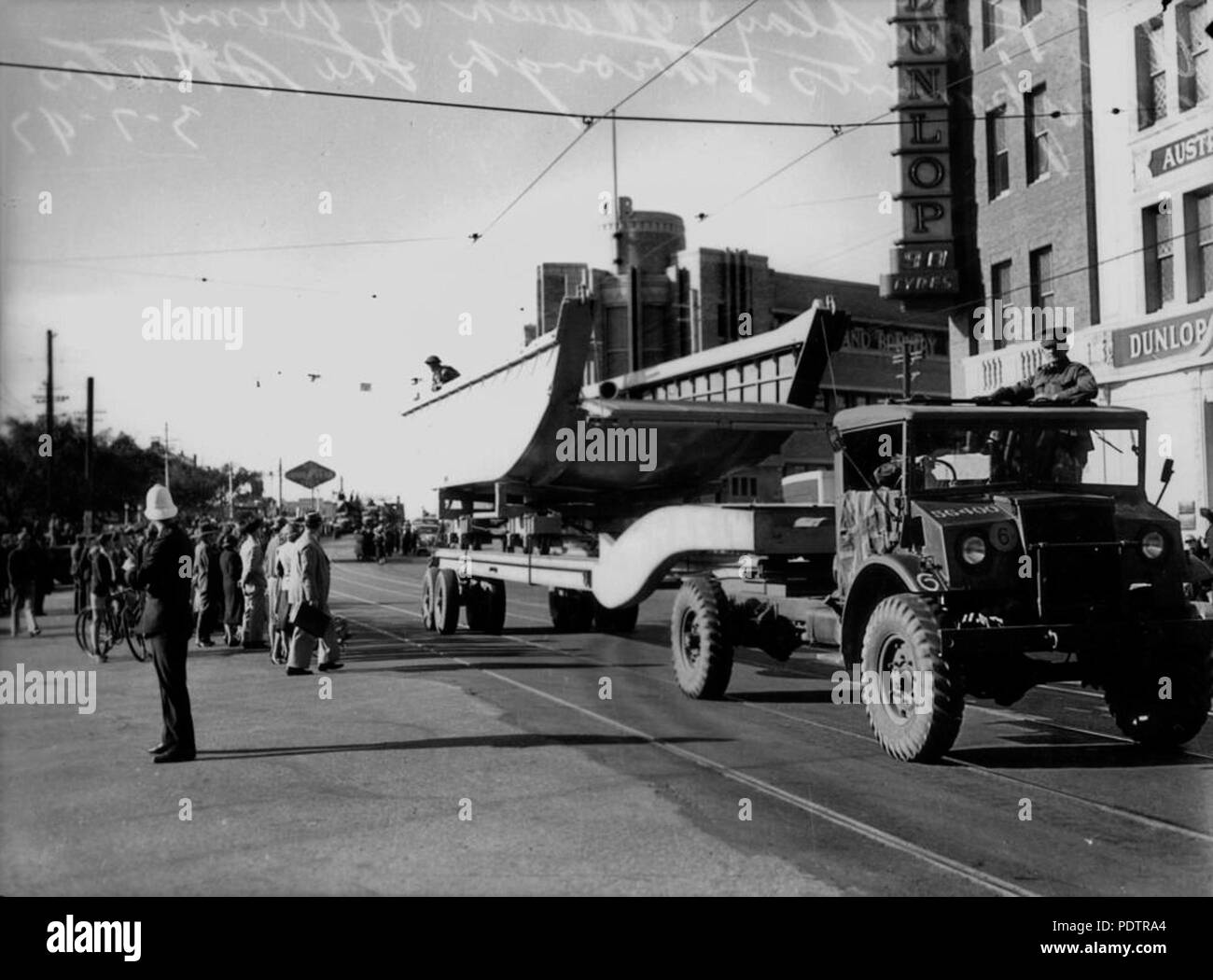 201 StateLibQld 1 104700 sfilata di attrezzature militari, tra cui un camion che trasportano una landing craft, Brisbane, Luglio 1942 Foto Stock