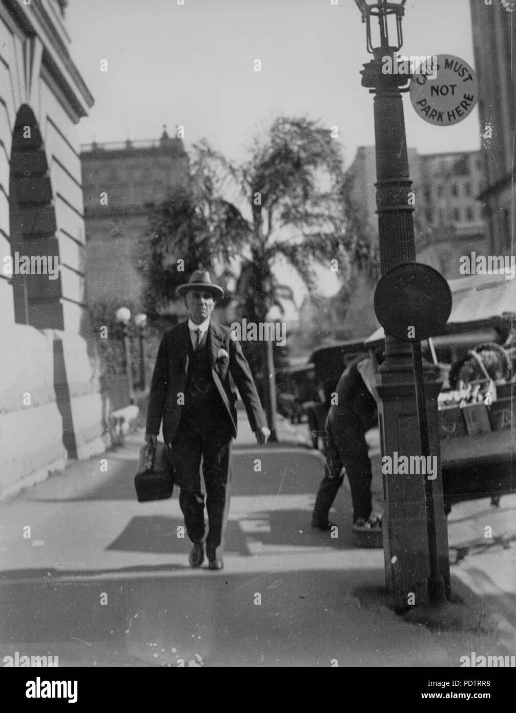 203 StateLibQld 1 108212 uomo a camminare lungo George Street, Brisbane, ca. 1931 Foto Stock