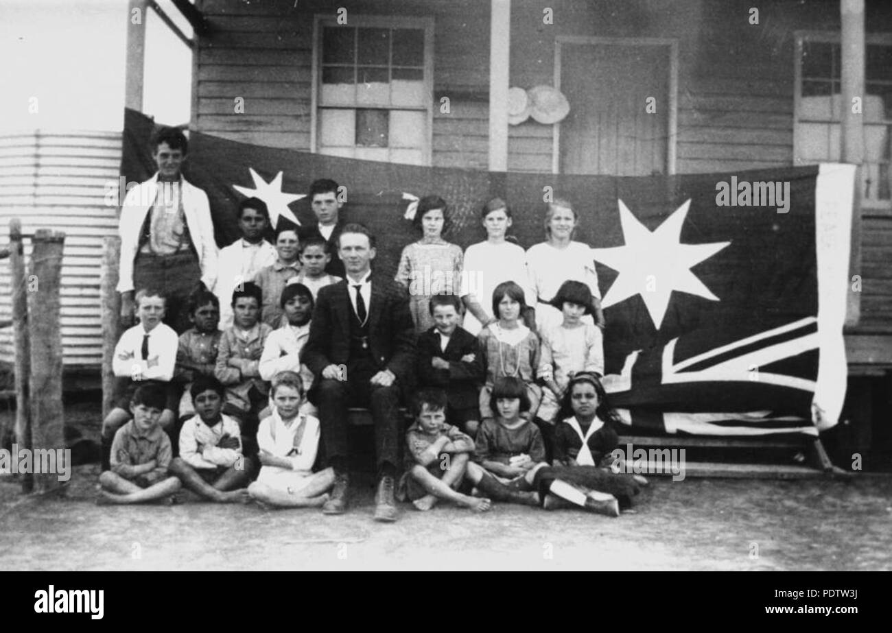 207 StateLibQld 1 testa 113620 insegnante e gli studenti al di fuori Hebel scuola statale, 1920 Foto Stock