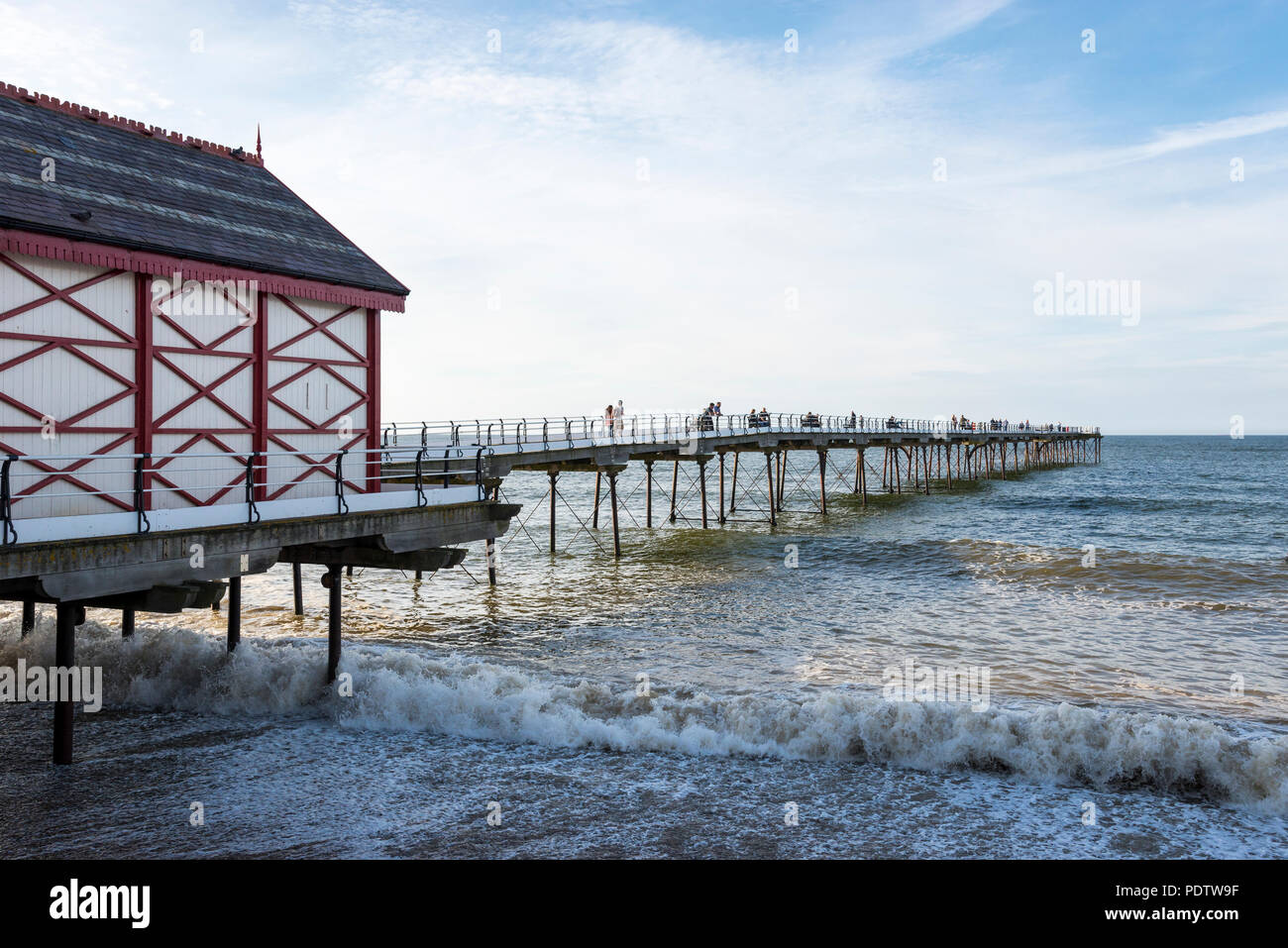 Per coloro che godono di una passeggiata lungo il molo vecchio a cambs sulla costa del North Yorkshire, Inghilterra. Una bella serata primaverile. Foto Stock