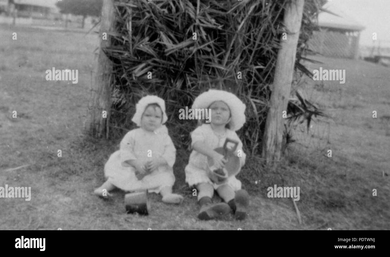 210 StateLibQld 1 118196 due piccoli bambini che giocano con le loro benne e picche a Cribb Isola, 1926 Foto Stock