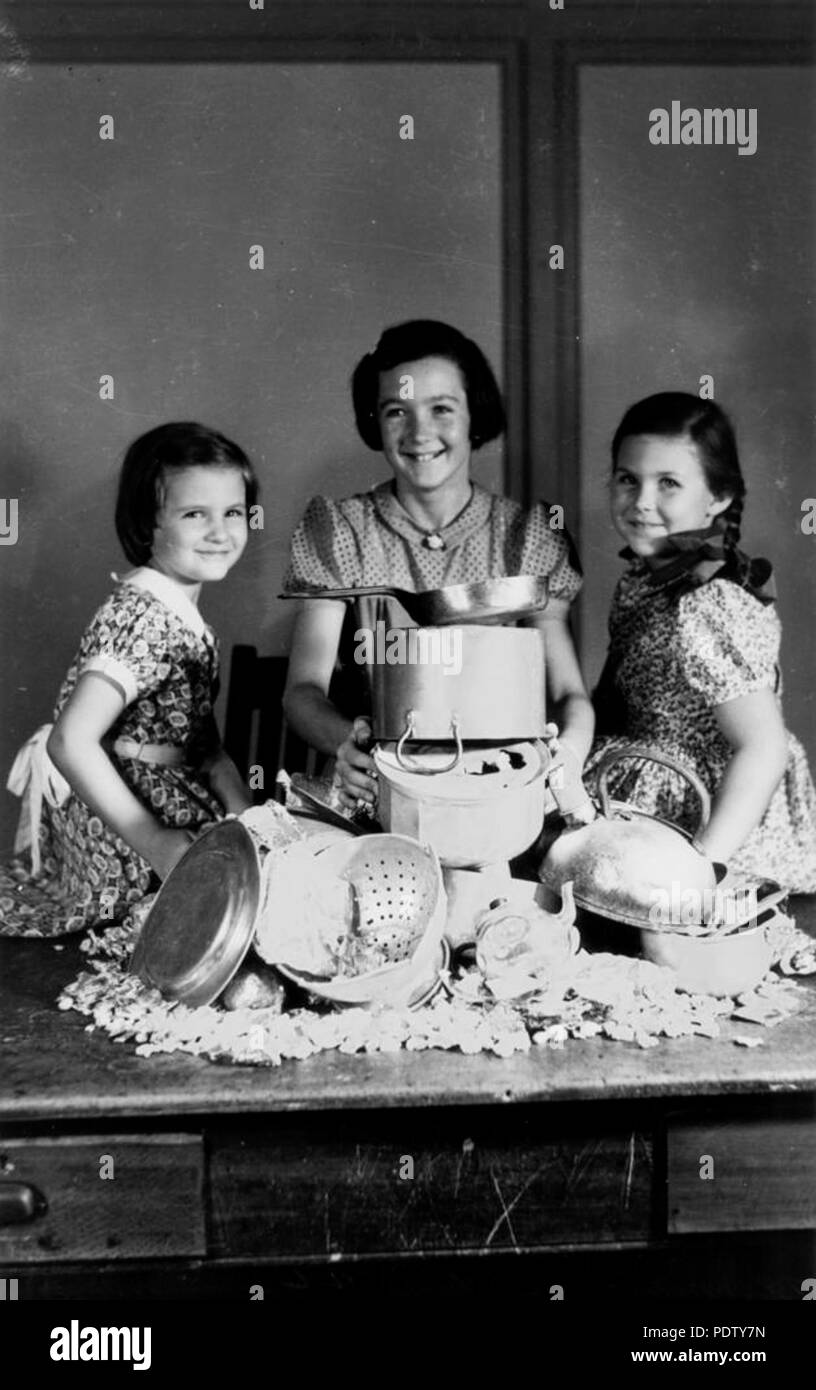 217 StateLibQld 1 131615 tre ragazze di contribuire allo sforzo bellico con la raccolta di vasi, Brisbane, 1942 Foto Stock