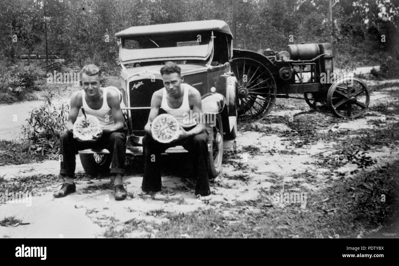 218 StateLibQld 1 132440 uomini godendo di anguria in un giorno caldo, 1935 Foto Stock