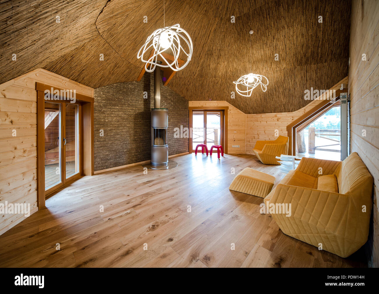 Elegante soggiorno con pavimento in legno e le pareti e il soffitto di paglia Foto Stock