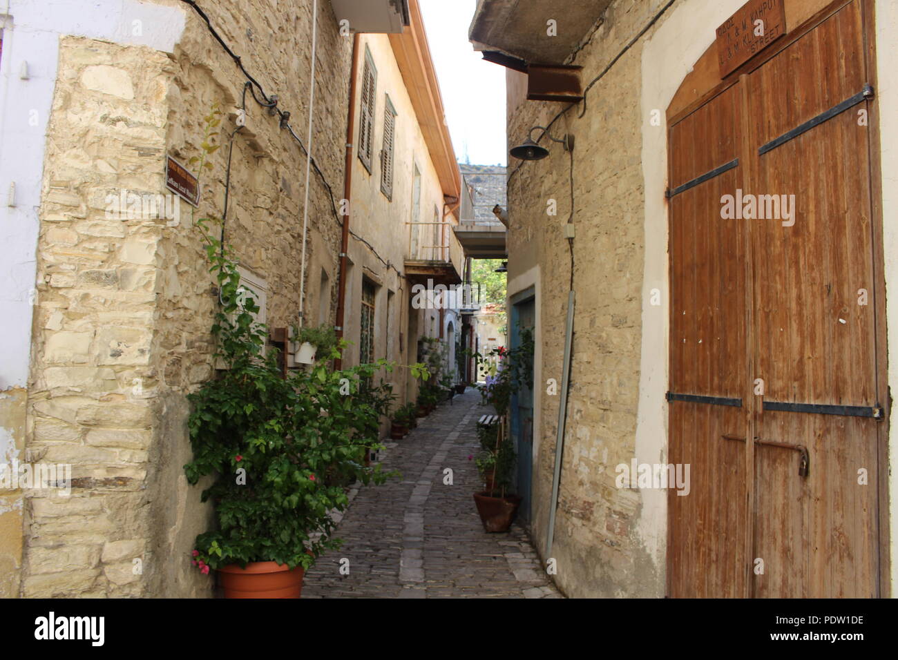 Strada stretta in Larnaca. Stretta strada a piedi tra le tradizionali case in pietra di Cipro Foto Stock