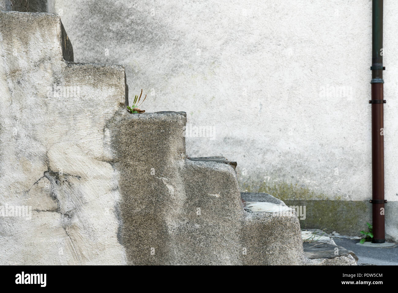 Free-standing vecchio rustico in pietra scale che portano verso l'alto con una casa di pietra anteriore dietro Foto Stock