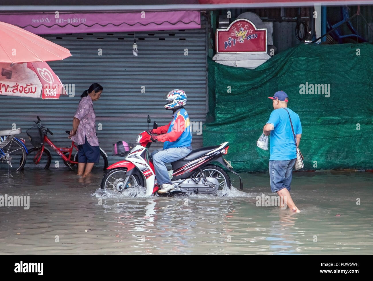SAMUT PRAKAN, Thailandia, NOV 02 2017, la gente e la moto si stanno muovendo in un invaso street. Le inondazioni nel mercato in Samut Prakan, Thailandia Foto Stock