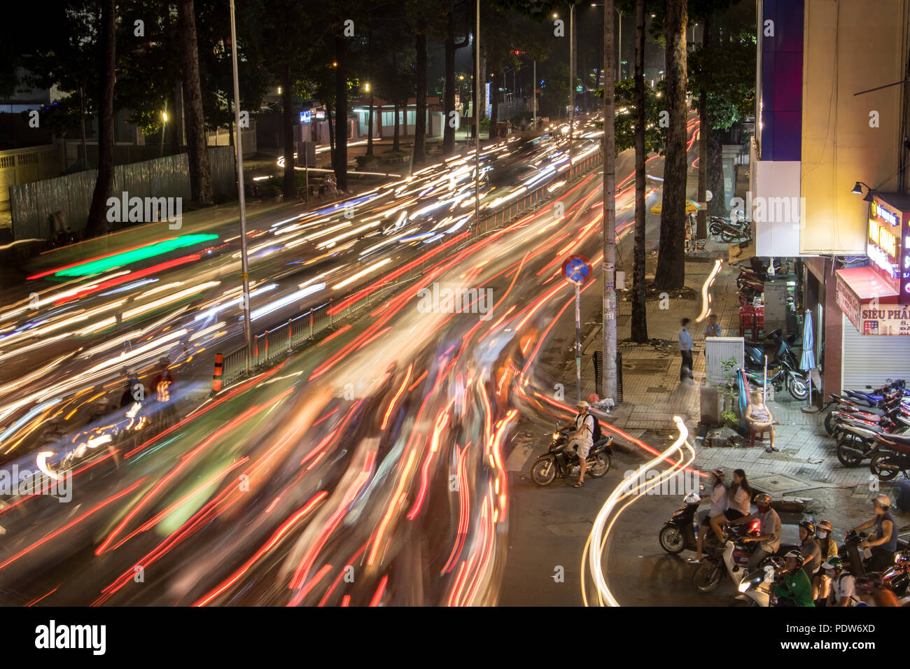 A Saigon, Vietnam, 14 dic 2017, alta densità di traffico di notte intersezione con luci sfocate passando per motocicli e veicoli. Foto Stock