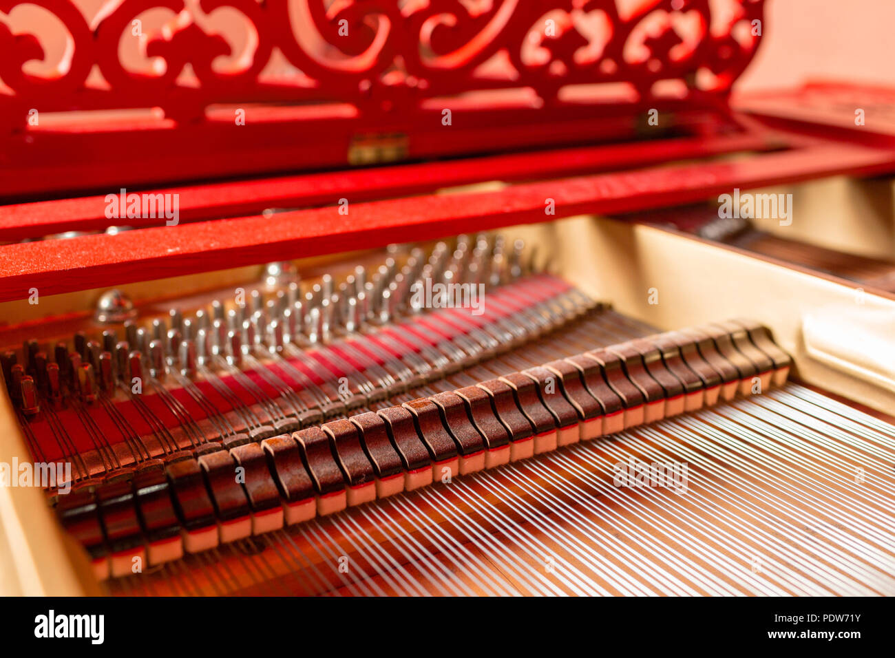 All'interno di stringhe in rosso di un grande pianoforte. A suonare il piano, ammortizzatori, feltro martelli, stringhe di bronzo e il telaio di metallo. Foto Stock