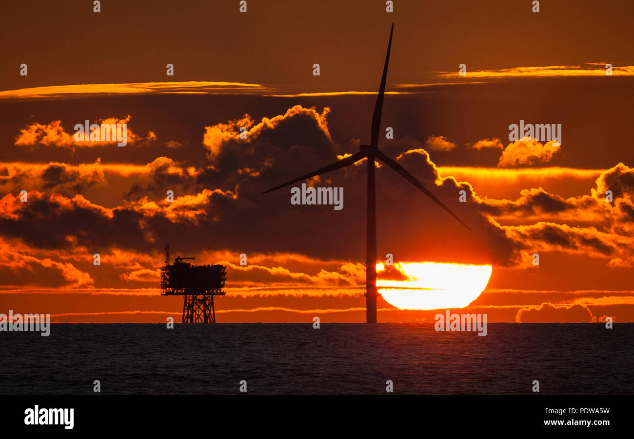 Tramonto su una turbina e sottostazione su Walney Estensione del parco eolico offshore Foto Stock