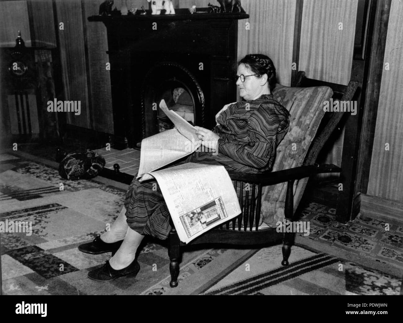 249 StateLibQld 1 201763 donna anziana leggendo il giornale, 1930-1940 Foto Stock
