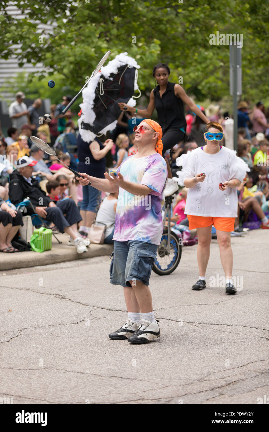Cleveland, Ohio, Stati Uniti d'America - 9 giugno 2018 uomo indossando vestiti colorati sballottando sfere con una racchetta all'arte astratta festival Parade il cerchio Foto Stock